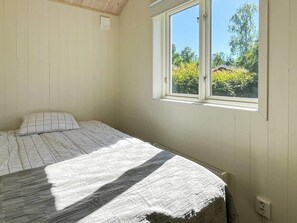 A bedroom with a single bed, a window with a view of greenery, and a wall-mounted air conditioning unit. - 7 Person Holiday Home in Rockneby (Rockneby)