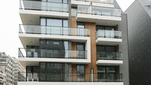 En flereetagers bygning med altaner, store vinduer og moderne arkitektur.