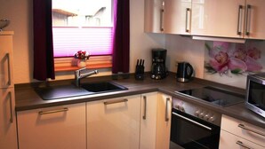 A modern kitchen with stainless steel appliances, a sink, and cabinets. - Holiday Apartment Alleblas (Geldern)