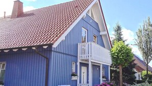 A blue house with a red-tiled roof, a white balcony, and a mailbox. - Holiday Apartment Alleblas (Geldern)