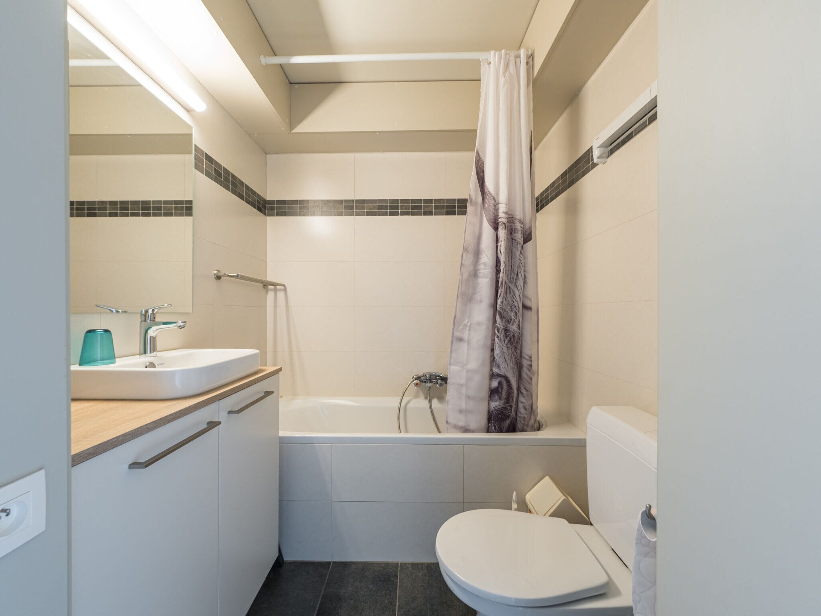 A modern bathroom with a bathtub, toilet, and sink.