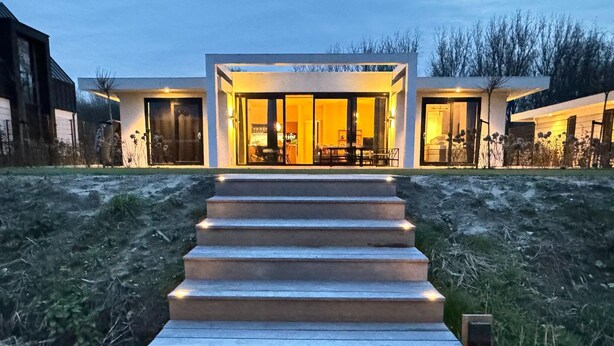 Una casa moderna con una escalera que conduce a una puerta de vidrio.