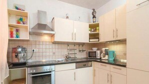 A kitchen with white cabinets, a microwave, a coffee maker, and a stove. - Apartment Stipic Omis - Three Bedroom Apartment With Terrace (Omis)