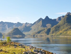 En sjö med berg i bakgrunden och en liten båt vid stranden.