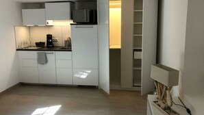 A compact kitchen with white cabinets, a microwave, and a coffee maker. - Balticliving Modern Retreat (Timmendorfer Strand)