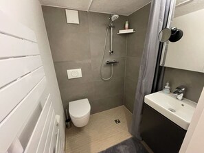 A compact bathroom with a shower, toilet, and sink. - Balticliving Modern Retreat (Timmendorfer Strand)