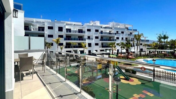 A rooftop with a pool, outdoor seating, and a view of a multi-story building. - Belvilla by OYO Playa Granada Beach & Golf 9 (Motril)