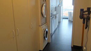 Ein Waschraum mit Waschmaschine, Trockner und Staubsauger.