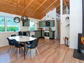 Une cuisine moderne avec un coin repas, un plancher en bois et une cheminée.