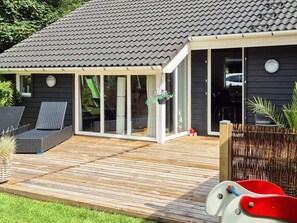 A house with a wooden deck, a sliding glass door, and a covered outdoor seating area. - 8 Person Holiday Home in Hemmet-by Traum (Hemmet)
