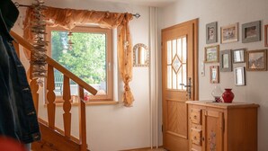 A wooden staircase leading to a room with a wooden door, a small cabinet, and a window with curtains. - Chalet in Filzmoos Near Tauern Mountains (Filzmoos)
