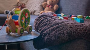 A toy train on a table, a teddy bear on a couch, and colorful building blocks scattered on the couch. - Chalet in Filzmoos Near Tauern Mountains (Filzmoos)