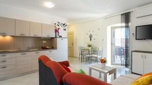 A modern apartment with a kitchen, dining area, and living room.