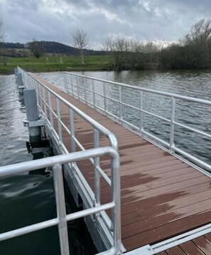 A wooden pier with metal railings extending over calm water. - Holiday Apartment in Klein Upahl (Klein Upahl)