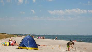 Een strand met tenten en mensen.