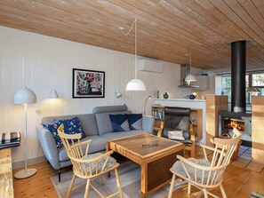 Una sala acogedora con sofá, sillones, una mesa de centro y chimenea.
