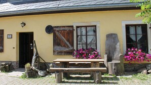 A traditional building with a yellow facade, wooden shutters, and a stone bench. - Holiday Apartment "pohlberg" (Annaberg-Buchholz)