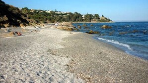 A pebble beach with clear blue water and rocky outcrops. - Penthouse With Terrace and sea Views (Casares)