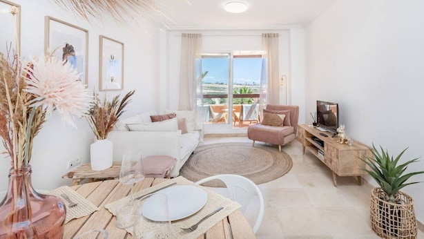 A modern living room with a sofa, a dining table set, a TV, and a balcony with a view. - Penthouse With Terrace and sea Views (Casares)
