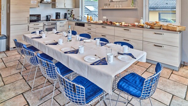 A modern kitchen with a dining area set for a meal.