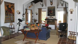 Un salon doté d’une cheminée, d’un téléviseur et de divers trophées de chasse exposés sur les murs.