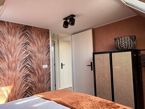 Ein Schlafzimmer mit einem Bett, einem Kleiderschrank und einer Tür zu einem anderen Raum.