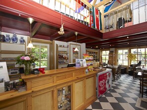 Ein Restaurant mit Schachbrettboden, Holztresen und diversen Ausstellungsstücken.