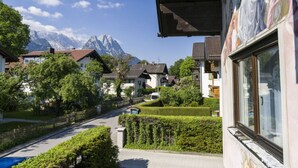 A residential street with houses, a road, and a mountain in the background. - Marlena Hollental Chalet (Garmisch-Partenkirchen)