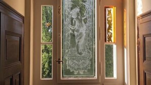 Une porte ornée de vitraux complexes et surmontée d’un arc décoratif.