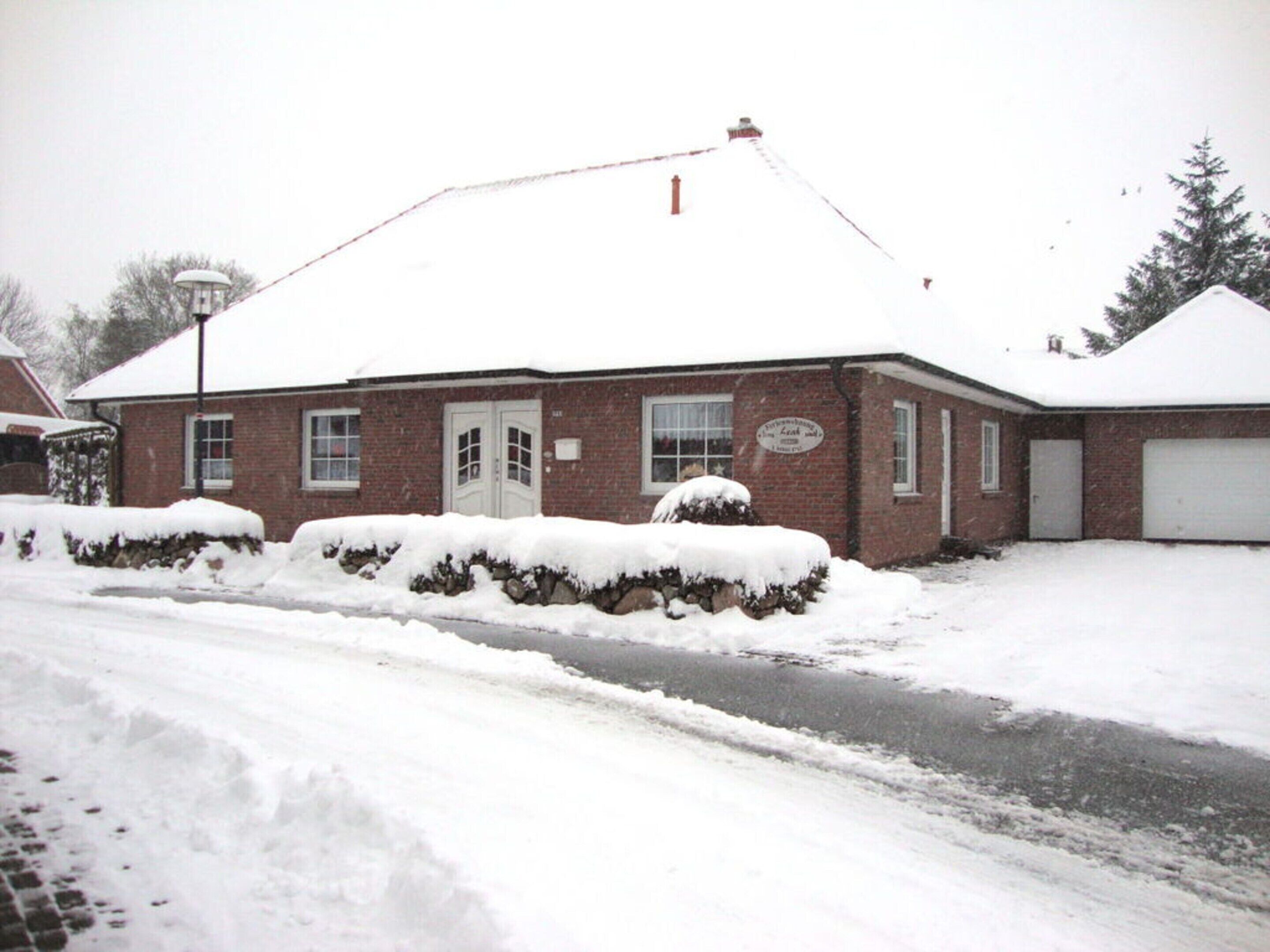Un edificio de ladrillo con techo nevado y un garaje.