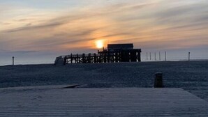 A wooden pier extending into calm waters during sunset. - Holiday Apartment Leah (Toenning)
