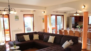 Ein modernes Wohnzimmer mit Ecksofa, Essbereich und Küche.