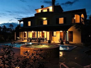 Uma casa grande com piscina e área de estar ao ar livre.