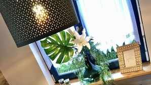 Una mesa de comedor dispuesta con platos, vasos y un florero con flores.