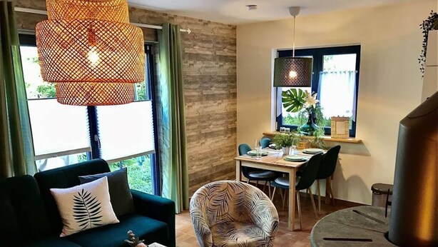 Una sala moderna con sofá, sillón, mesa de centro y comedor con mesa y sillas.
