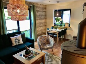 A modern living room with a sofa, armchair, coffee table, and a dining area with a table and chairs. - Favorite Piece of Modern Retreat (Oberharz am Brocken)