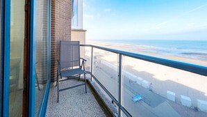 Varanda com vista para a praia e uma cadeira.