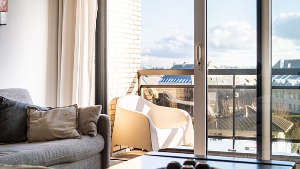 Un salon moderne comprenant un canapé, un fauteuil et une table agrémentée d’objets décoratifs.