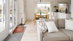 Una sala de estar acogedora con un sofá, una mesa de comedor y una zona de cocina.