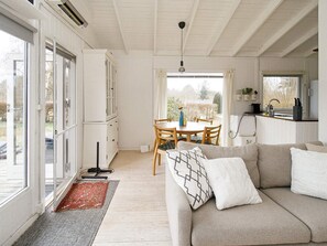 Una sala de estar acogedora con un sofá, una mesa de comedor y una zona de cocina.