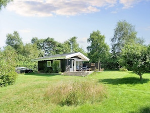 A single-story house with a porch, a car parked in the driveway, and a well-maintained lawn. - 4 Person Holiday Home in Graested (Graested)