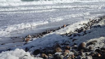 Una costa rocosa con olas rompiendo en la playa.