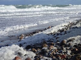 A rocky shoreline with waves crashing onto the beach.