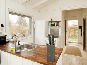 A kitchen with a wooden countertop, stainless steel sink, and a built-in stove.