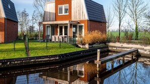 A modern house with a large patio, a swimming pool, and a wooden deck. - Spacious Holiday Home With Outdoor spa (Akkrum)
