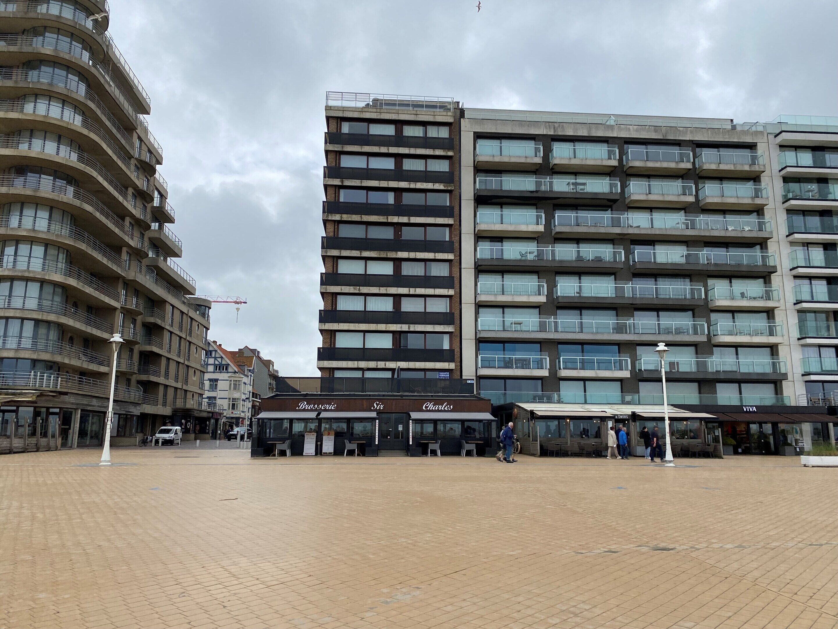 A modern building with multiple balconies and a flat roof.