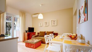 A modern living room with a sofa, chairs, a dining table, and a kitchen area. - Comfortable Apartment With Private Terrace (Fazana)