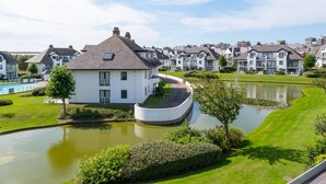 Een woonwijk met huizen, een vijver en een zwembad.