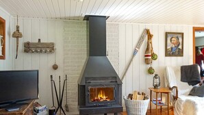 A cozy living room with a wood-burning stove, a television, and a comfortable seating area. - 6 Person Holiday Home in Munkedal-by Traum (Munkedal)