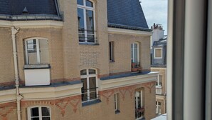 Un immeuble à plusieurs étages, doté de façades en briques, de nombreuses fenêtres et de balcons.